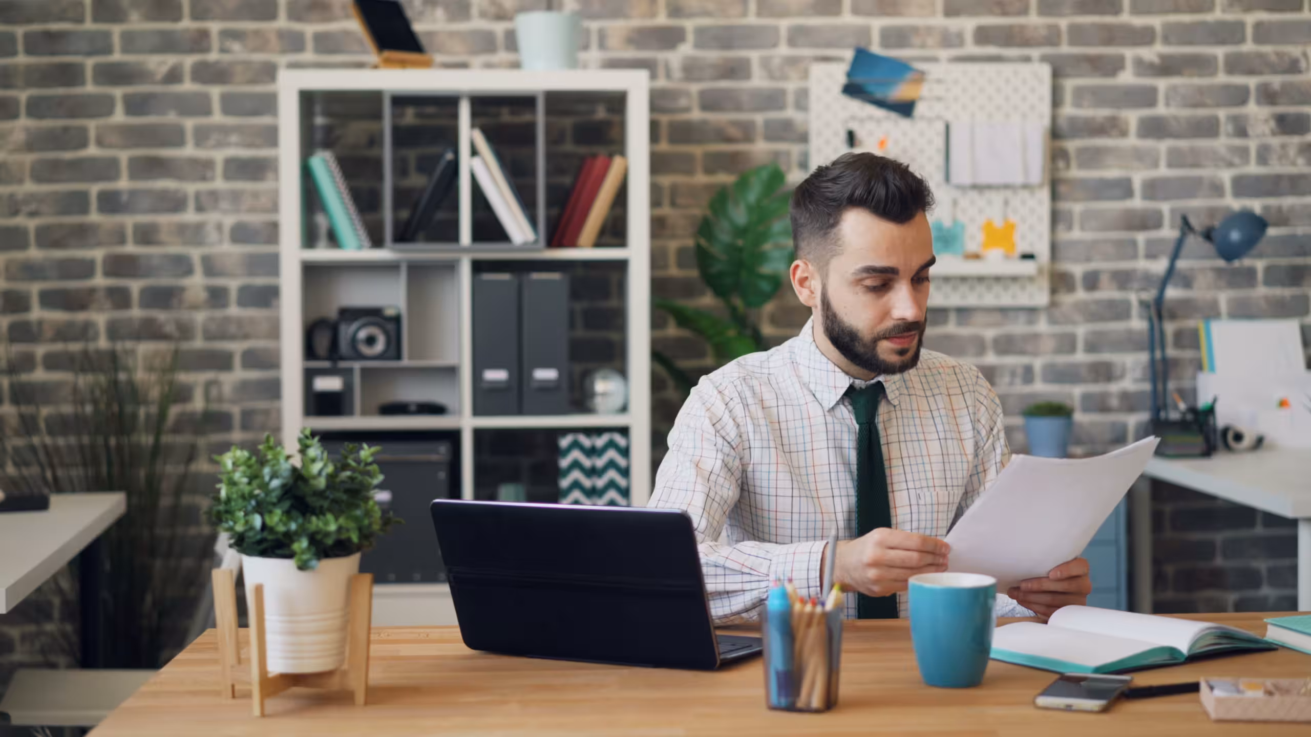 Someone implementing a new CLM system with a computer, papers, and a mug of coffee.