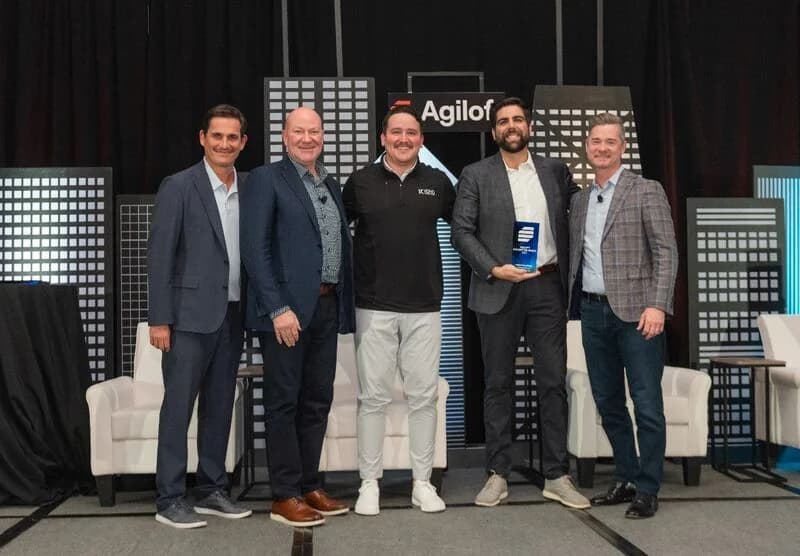Koho team members receiving an Agiloft partner award on stage.